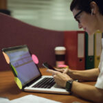 mulher jovem estudando pelo notebook com post its